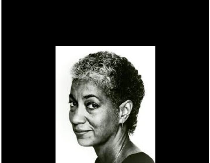 Black-and-white portrait of June Jordan — short salt-and-pepper curls, slight smile, looking just past the camera.